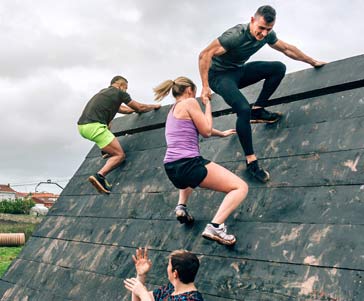 People climbing up an obstacle.